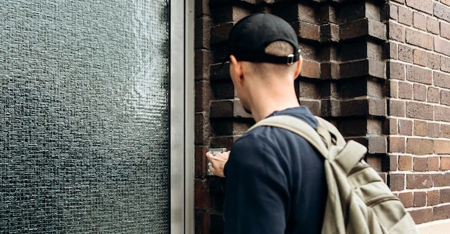 Il turista suona il campanello per fare il check-in nella stanza che ha prenotato. (Alamy Stock Photo)