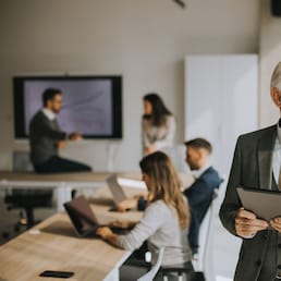 Handsome senior business man working on digital tablet in the office