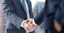 closeup of handshake of business partners on the background of business team