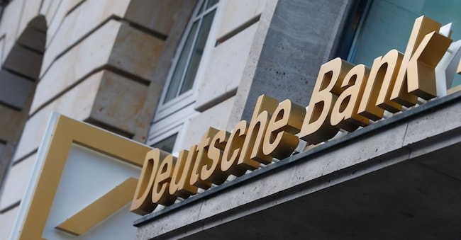 Il logo esposto all'esterno di una filiale di Deutsche Bank AG a Francoforte, in Germania, martedì 29 ottobre 2013. Deutsche Bank AG, la più grande banca d'investimento europea per fatturato, ha dichiarato che l'utile del terzo trimestre è sceso del 94% dopo aver accantonato 1,2 miliardi di euro (1,65 miliardi di dollari) per coprire le spese legali previste e il reddito derivante dalla negoziazione del debito è diminuito. Fotografo: Ralph Orlowski/Bloomberg