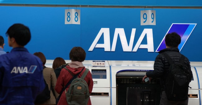 Passengers check in their luggage at the ANA baggage check-in counter at Haneda Airport in Tokyo on November 29, 2025. Several airlines announced delayed or cancelled flights following an Airbus alert that up to 6,000 operational A320 family of aircraft may require upgrades. (Photo by Kazuhiro NOGI / AFP)