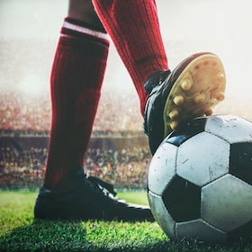 feet of soccer player tread on soccer ball for kick-off in the stadium