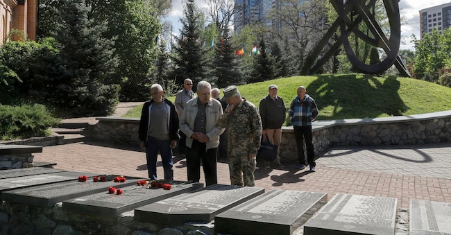  Persone depongono fiori sulle targhe del monumento che onora coloro che sono morti durante le operazioni di bonifica dopo il disastro nucleare di Chernobyl, in occasione dell’anniversario, a Kiev, in Ucraina, il 26 aprile 2025, durante l'invasione russa. (EPA/Sergey Dolzhenko)