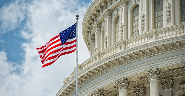 Particolare della cupola del Campidoglio di Washington DC con bandiera americana sventolante. (Andrea Izzotti - Adobe Stock)