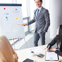 Workers at business meeting looking at presentation of financial reports in modern office
