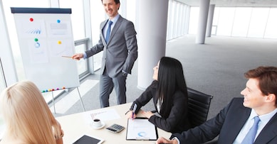 Workers at business meeting looking at presentation of financial reports in modern office