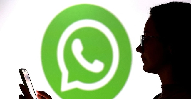 FILE PHOTO: A teenager poses for a photo while holding a smartphone in front of a Whatsapp logo in this illustration taken September 11, 2025. REUTERS/Dado Ruvic/Illustration/File Photo