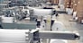 A industrial commercial envelope making machine, making paper envelopes for international distribution. Automated engineering machinery for mass production of paper envelopes.