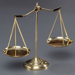 Shiny golden balanced scale in courtroom background as concept justice and a common legal symbol. Scale balance for righteous and equality judgment by lawyer and attorney. Equilibrium