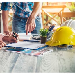 Asian engineer man brainstorming teams partner meeting office desk on construction site. Engineering men building contractor civil worker team meeting together. Men look at construction Blueprint