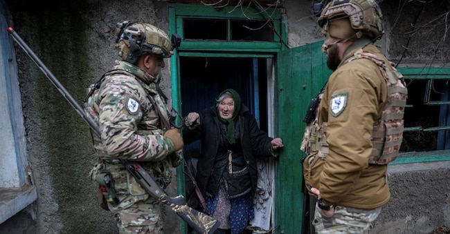 Membri dell'unità di evacuazione della polizia degli Angeli Bianchi parlano con una residente durante l'evacuazione dalla città di Dobropillia, in Ucraina, durante l'attacco russo all'Ucraina, nella regione di Donetsk