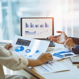 A male business consultant describes a marketing plan to set business strategies for women business owners with using calculator. business planning and business researching concept.