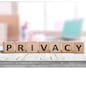 Privacy sign on a wooden table in a bright room with a computer