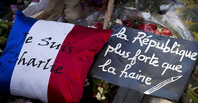 Una scritta con i colori della bandiera francese che recita "Je suis Charlie" (Io sono Charlie) e un cartello che recita "Repubblica più forte dell'odio" sono posati fuori dalla sede del settimanale satirico francese Charlie Hebdo a Parigi il 7 febbraio 2015, in memoria delle vittime un mese dopo il mortale attacco jihadista al giornale che ha ucciso 12 persone, tra cui i celebri vignettisti. Gli attacchi islamici armati contro Charlie Hebdo, una poliziotta e una drogheria kosher ebraica a Parigi dal 7 al 9 gennaio hanno causato un totale di 17 morti. L'assalto ha sconvolto la Francia e lo slogan "Je suis Charlie", in solidarietà con le vittime, è diventato un grido globale contro l'estremismo.  (Foto di Joël Saget / AFP)