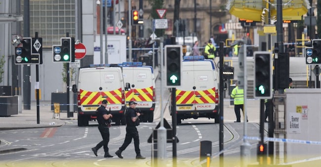 Pattuglie di polizia armate vicino alla Manchester Arena dopo un attacco terroristico mortale a Manchester, nel nord-ovest dell'Inghilterra, il 23 maggio 2017. Ventidue persone sono state uccise e decine ferite nell'attacco terroristico più letale in Gran Bretagna in oltre un decennio, dopo che un sospetto attentatore suicida ha preso di mira i fan che lasciavano un concerto della cantante statunitense Ariana Grande a Manchester. (Foto di Oli Scarff / AFP)