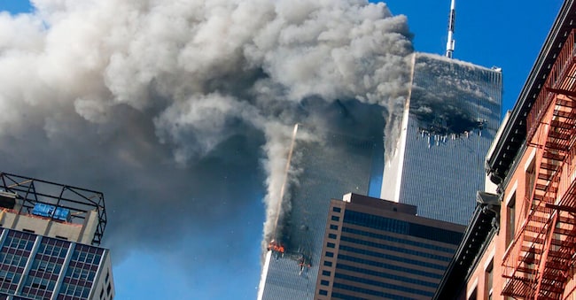 Il fumo si leva dalle torri gemelle del World Trade Center in fiamme dopo che gli aerei dirottati si sono schiantati contro le torri, l'11 settembre 2001, a New York. (Foto AP/Richard Drew)