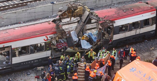 I soccorritori coprono i corpi accanto a un treno passeggeri danneggiato da una bomba, in seguito a una serie di esplosioni a Madrid, in Spagna, l'11 marzo 2004. Le vittime degli attentati terroristici sono un simbolo della costante necessità di proteggere la libertà e lo stato di diritto dalle minacce, ha dichiarato il re Felipe VI di Spagna lunedì 11 marzo 2024 in occasione della cerimonia per il 20° anniversario di uno dei più letali attacchi estremisti in Europa. (Foto AP/Paul White)