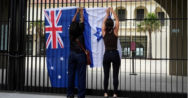 Donne collocano una bandiera israeliana accanto a una bandiera australiana su un cancello all'esterno del Bondi Pavilion a Bondi Beach di Sydney, dopo la sparatoria
