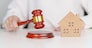 Real Estate Law, Home Insurance, property Tax, Auction and Bidding concepts. small toy house model with gavel justice hammer on desk in courthouse