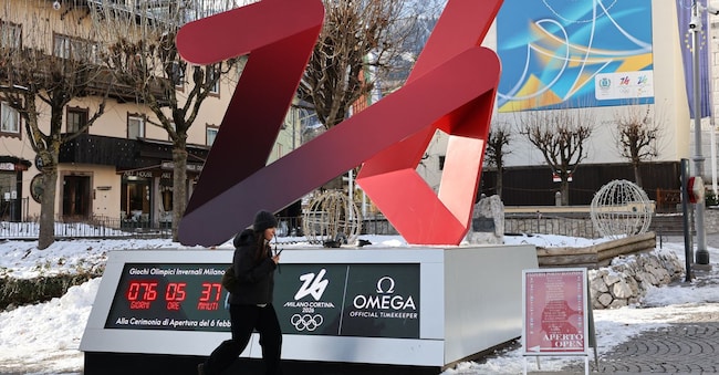 Una donna passa davanti al tabellone del conto alla rovescia dei Giochi Olimpici Invernali di Milano-Cortina 2026, a Cortina d'Ampezzo. Situata nella regione settentrionale del Veneto, Cortina d'Ampezzo è famosa per la sua bellezza, la sua stazione sciistica e la sua eredità sportiva, a partire dai Giochi Olimpici Invernali del 1956 fino a Milano-Cortina 2026. (Foto di Li Jing / Xinhua via AFP)