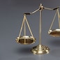 Shiny golden balanced scale in courtroom background as concept justice and a common legal symbol. Scale balance for righteous and equality judgment by lawyer and attorney. Equilibrium