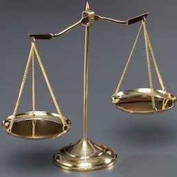 Shiny golden balanced scale in courtroom background as concept justice and a common legal symbol. Scale balance for righteous and equality judgment by lawyer and attorney. Equilibrium