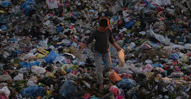 Un ragazzo palestinese rovista tra i rifiuti in una discarica nel campo di al-Bureij, nella Striscia di Gaza centrale, mercoledì 24 dicembre 2025. 