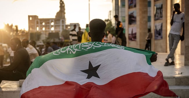 (FILES) A man holds a flag of Somaliland in front of the Hargeisa War Memorial monument in Hargeisa on November 7, 2024. Somaliland's president on December 26, 2025 welcomed Israel's announcement that it was recognising its statehood and said the decision marked the beginning of a "strategic partnership". "This is a historic moment as we warmly welcome... the Prime Minister of the State of Israel's recognition of the Republic of Somaliland and affirm Somaliland's readiness to join the Abraham Accords," normalising relations with Israel, Abdirahman Mohamed Abdullahi posted on X. Israeli Prime Minister Benjamin Netanyahu's office said earlier that the country formally recognised Somaliland, which declared independence from Somalia in 1991, as an "independent and sovereign state". (Photo by LUIS TATO / AFP)