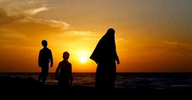 Una famiglia palestinese cammina lungo la riva del mare la notte di Capodanno a Gaza City. REUTERS/Mahmoud Issa     TPX IMAGES OF THE DAY