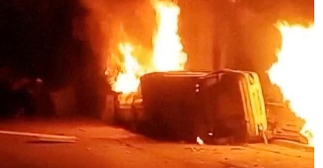 Una macchina ribaltata avvolta in un incendio mentre chi protesta canta fuori dalla stazione di polizia durante le manifestazioni anti-regime in Iran ad Azna in questa immagine pubblicata dai social media/via REUTERS .
