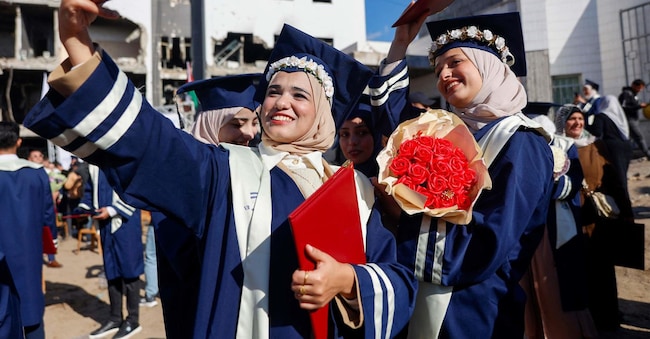 Studenti delle facoltà di medicina delle università islamiche e di Al-Azhar scattano un selfie durante la cerimonia di laurea di 230 medici nel cortile dell'ospedale Al-Shifa di Gaza City, il 3 gennaio 2026. Un fragile cessate il fuoco è in vigore da ottobre, dopo una guerra mortale condotta da Israele in risposta all'attacco senza precedenti di Hamas del 7 ottobre 2023 contro Israele. (Foto di Omar AL-QATTAA / AFP)