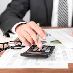 Businessman working with using a calculator to calculate the numbers. Finance accounting concept