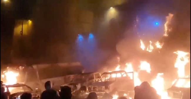 Alcune macchine prendono fuoco durante le proteste a Teheran in un’immagine postata sui social media 