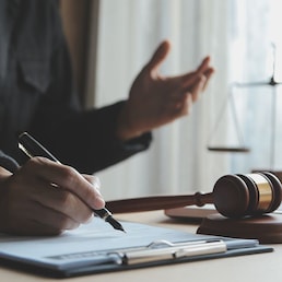 Business and lawyers discussing contract papers with brass scale on desk in office. Law, legal services, advice, justice and law concept picture with film grain effect