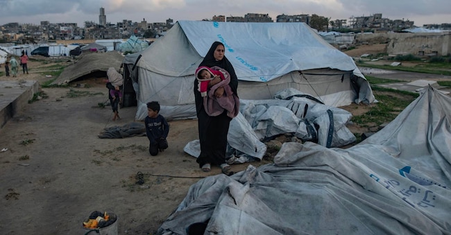 Una famiglia palestinese cerca di raccogliere ciò che resta dei propri averi dopo che la loro tenda è stata danneggiata a Khan Younis, nella Striscia di Gaza meridionale, il 9 gennaio 2026. La tenda che ospitava la famiglia palestinese è stata distrutta da forti venti e piogge intense, lasciando la famiglia senza riparo.  EPA/HAITHAM IMAD
