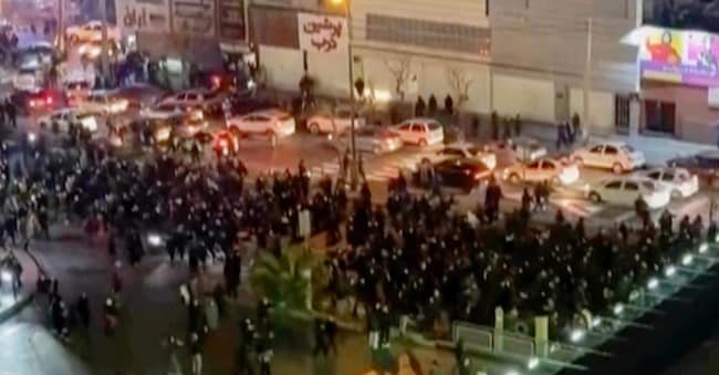 In questo fotogramma tratto da un video girato da una persona non dipendente dell'Associated Press e ottenuto dall'AP fuori dall'Iran, si vedono persone che bloccano un incrocio durante una protesta a Teheran, in Iran. (UGC via AP)