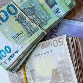 Bundles of European banknotes tied with rubber bands.