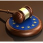 European Union laws, legal system and parliament concept with a 3d render of a gavel on a wooden desktop and the EU flag.