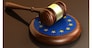 European Union laws, legal system and parliament concept with a 3d render of a gavel on a wooden desktop and the EU flag.