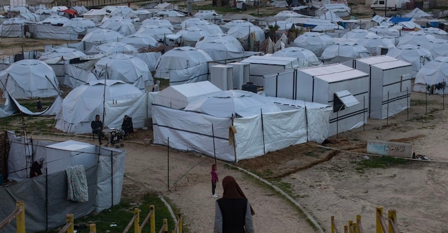 epa12659211 Palestinesi sfollati accanto alle loro tende in un campo provvisorio allestito nella città di Khan Younis, nella Striscia di Gaza meridionale, il 18 gennaio 2026. Secondo le Nazioni Unite, circa il 90% della popolazione, ovvero 1,9 milioni di persone a Gaza, è stato sfollato dall'inizio del conflitto.  EPA/HAITHAM IMAD