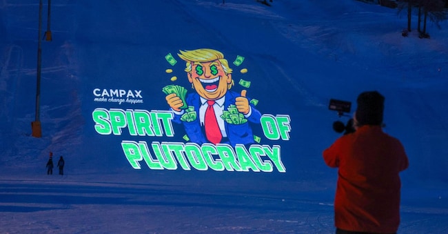 Attivisti dell'Ons svizzera Campax proiettano un'immagine cartoon del presidente degli Stati Uniti Donald Trump su una pista da sci durante una protesta contro la sua partecipazione all'incontro annuale del World Economic Forum a Davos