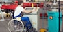 disabled worker in wheelchair in factory on the machine