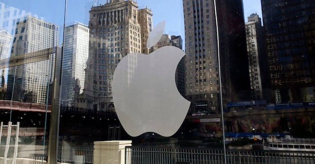 Gli edifici si riflettono dietro il logo di un Apple Store nel centro di Chicago. (AP Photo/Kiichiro Sato, File)