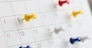 Various color thumb tack pins on calendar as reminder. Important business days concept