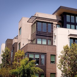 Exterior view of modern apartment building. New construction apartment or condo complex. Modern new residential apartment house building complex, some trees in the front