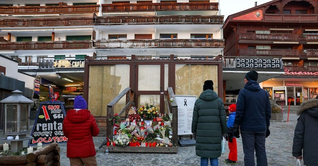 Persone in piedi davanti a un memoriale improvvisato fuori dal bar "Le Constellation" quasi un mese dopo un incendio mortale durante una festa di Capodanno, nella lussuosa località sciistica di Crans-Montana, Svizzera, 31 gennaio 2026. REUTERS/Denis Balibouse/Foto d'archivio