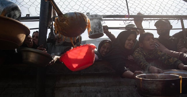 Palestinesi sfollati ricevono cibo a Khan Yunis, nel sud della Striscia  EPA/HAITHAM IMAD