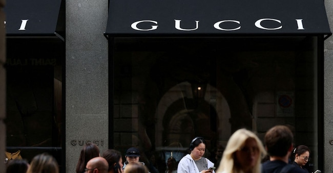 FILE PHOTO: People stand in front of a Gucci store in Milan, Italy, September 24, 2025. REUTERS/Yara Nardi/File Photo