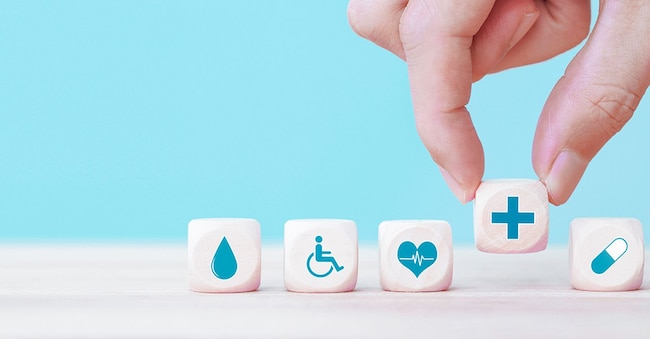 Hand chooses a emoticon icons healthcare medical symbol on wooden block , Healthcare and medical Insurance concept Mizkit - stock.adobe.com