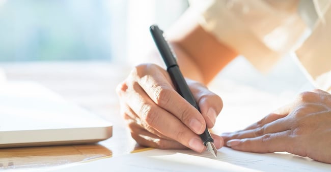 Asian Business woman signing a contract document making a deal.